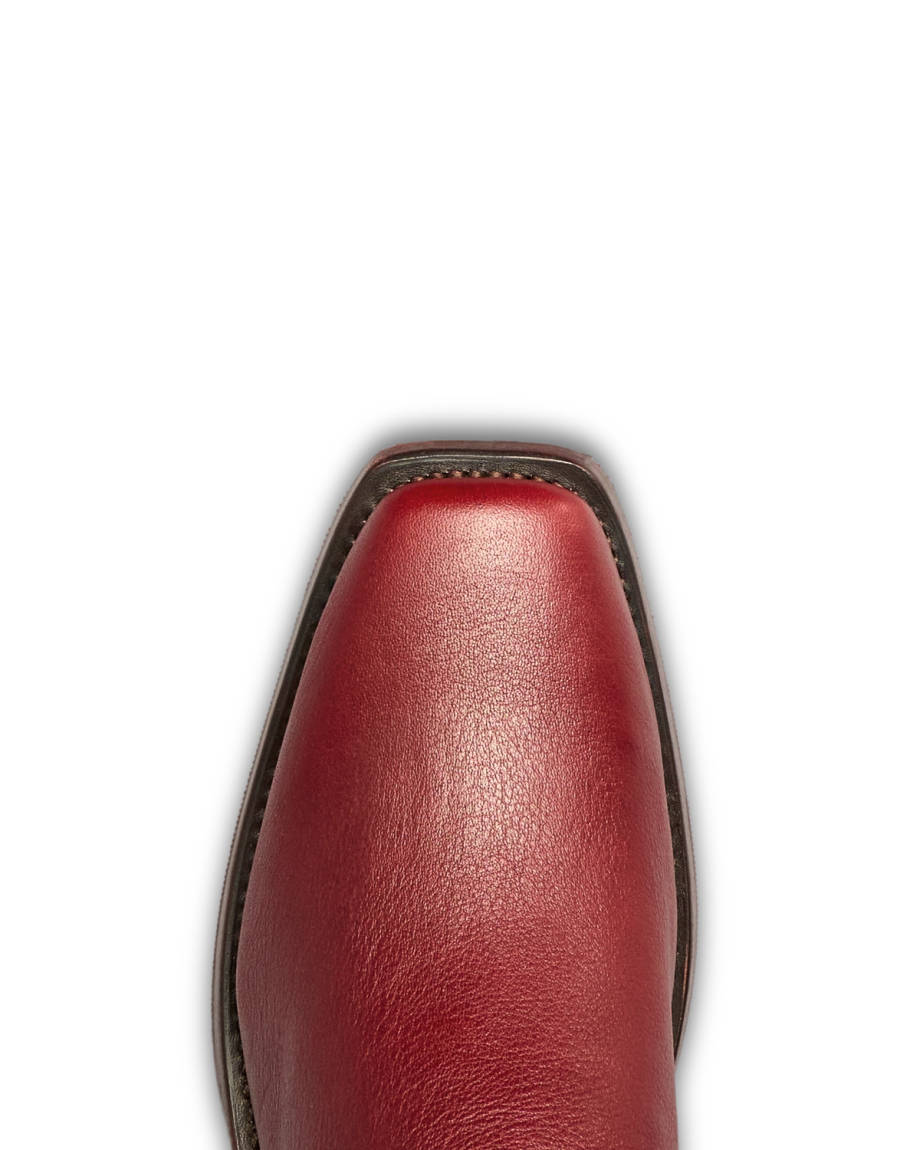 Close-up view of the toe of The Charlie Cowhide shoe in Scarlet red leather, featuring a square shape, dark sole edge, and visible cowhide texture, photographed against a white background.