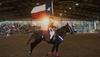 Cowboy in a rodeo holding Texas flag