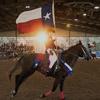 Cowboy in a rodeo holding Texas flag