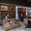 Tecovas Kingston Pike store interior. Displaying boots, hats, and leather goods on shelves and in glass cases, with natural light from large windows and neatly organized merchandise.