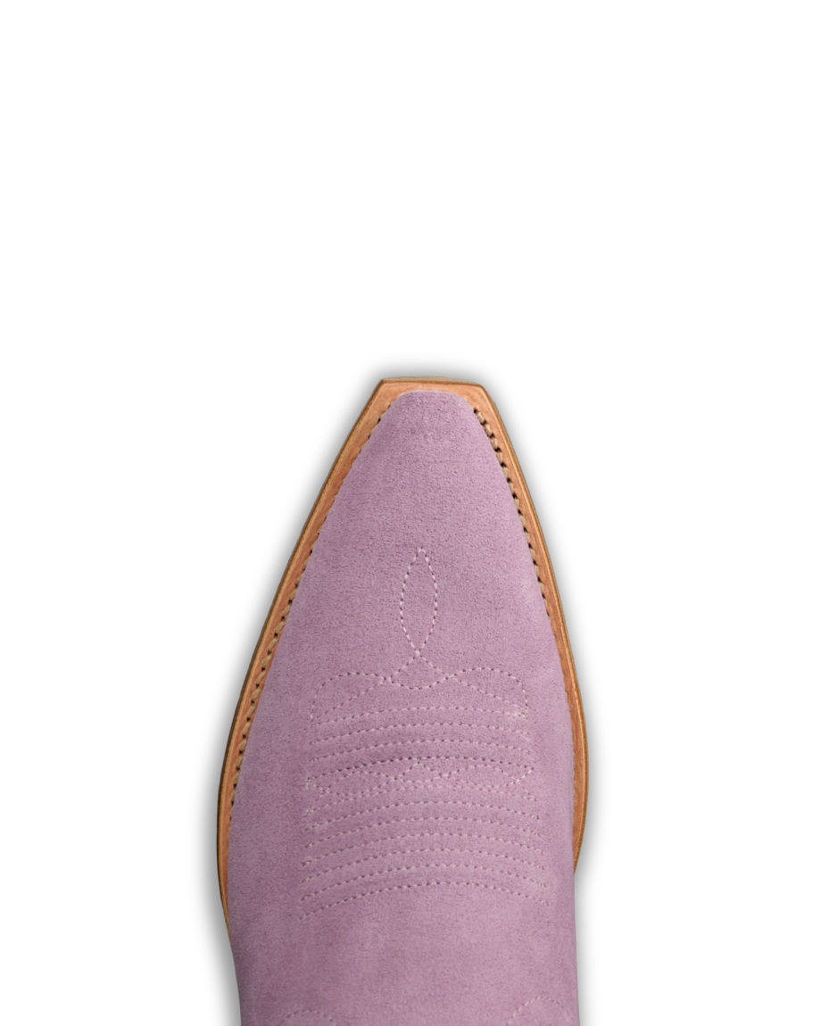 The Annie in Lavender Suede. Close-up of the pointed toe of a Lavender Suede cowboy boot with decorative stitching and a light brown sole, set against a white background.