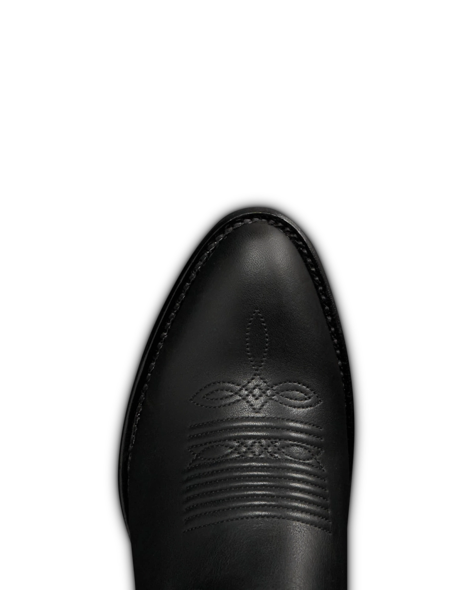 The Britt in Midnight Cowhide. Close-up view of the toe of a black Midnight Cowhide cowboy boot with decorative stitching on the top.