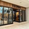 Exterior of a Tecovas store in a shopping mall, showing large glass windows and a wooden sign above the entrance.