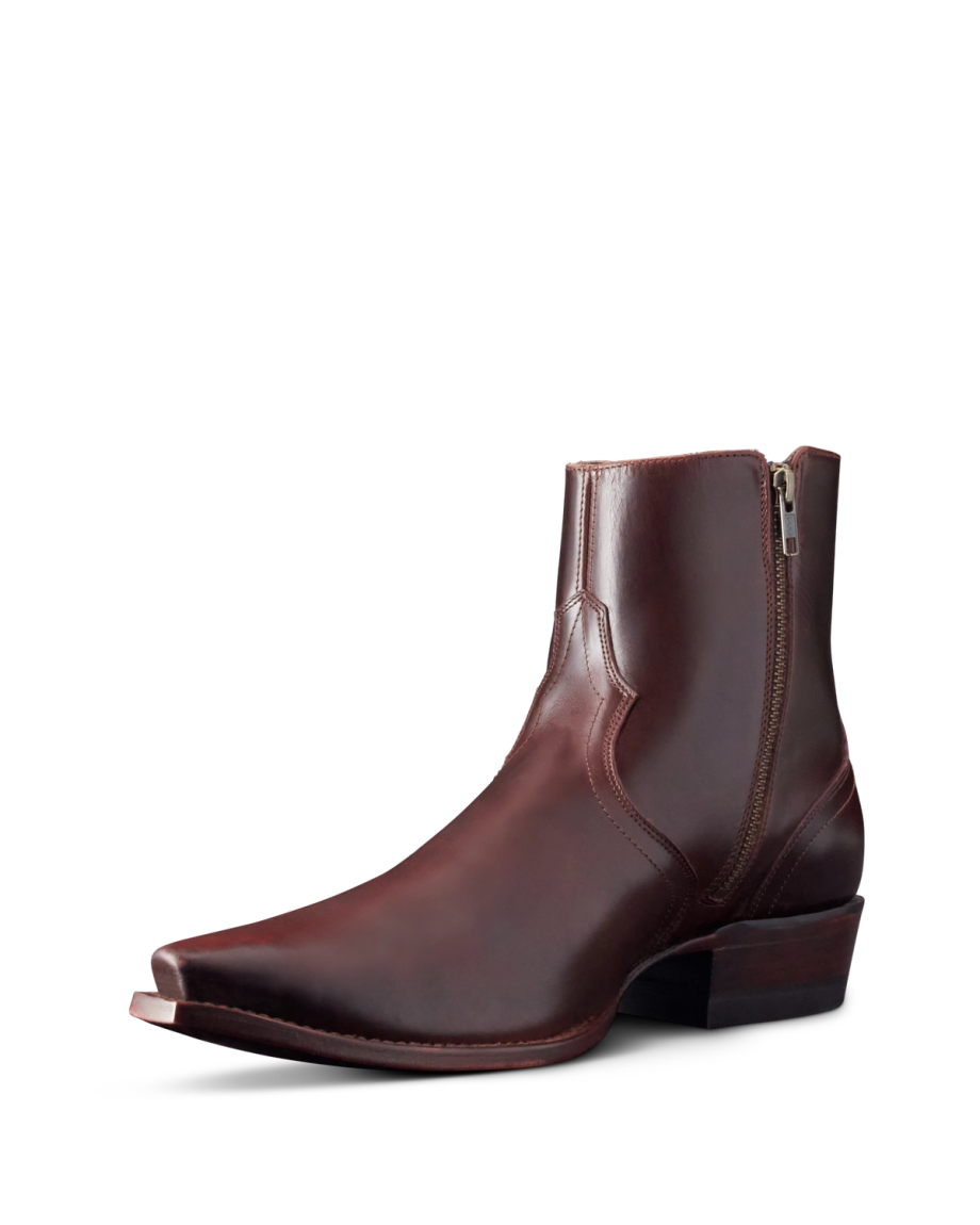 A brown leather ankle boot with a pointed toe and stacked heel. It features side stitching and a zipper on the side.