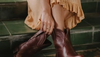 Woman wearing yellow sundress and brown booties