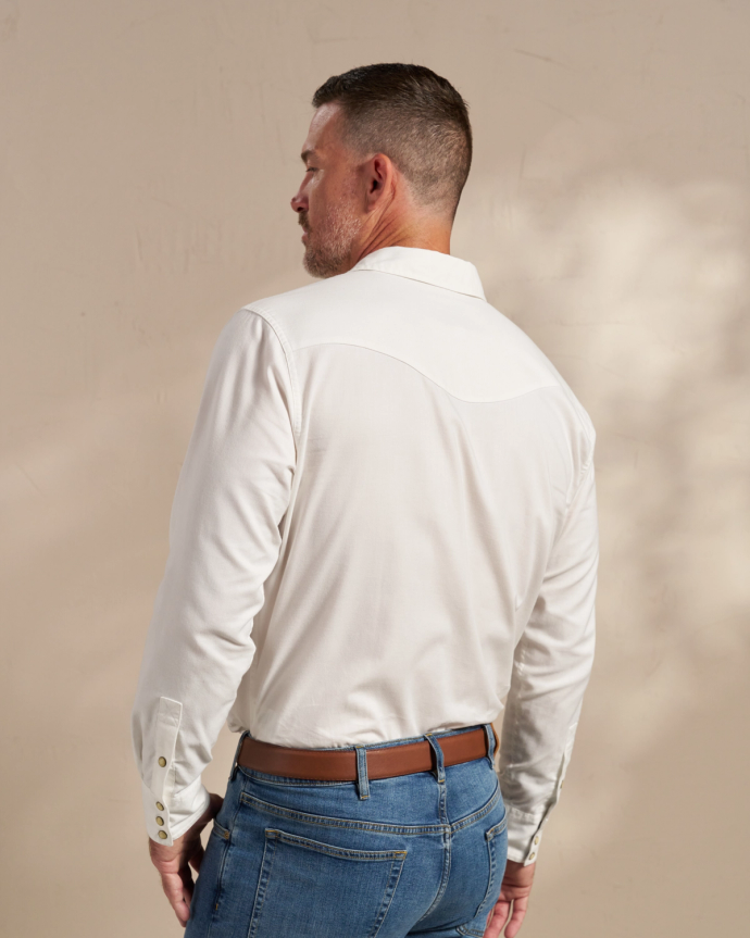 Man wearing a white pearl snap in a photo studio