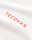 White fabric with the word "TECOVAS" printed in red, capital letters in a simple font.