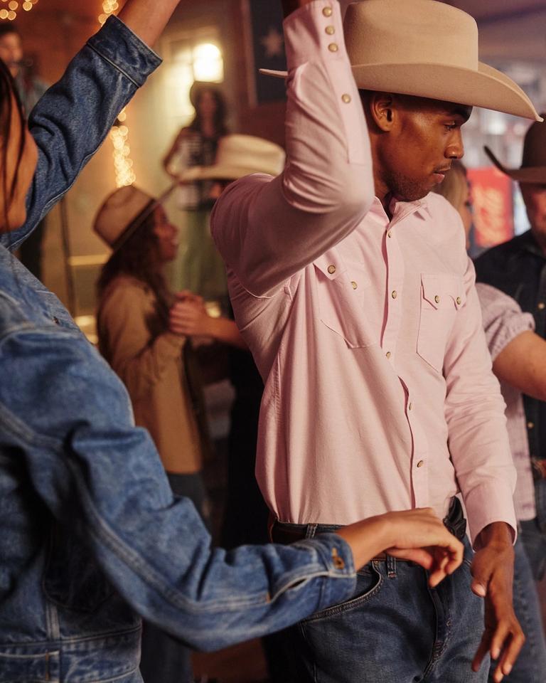 A group of people in cowboy hats dancing at a party.