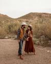 Men and Woman standing in dirt wearing boots and hats