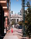 A family walks on a sidewalk in a sunny city street, with a historic building with the text "union station" in the background.