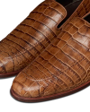 The Bennett in Saddle Alligator. Close-up of The Bennett Alligator brown leather dress shoes with a striking alligator skin texture, visible stitching, and a sleek, polished finish.
