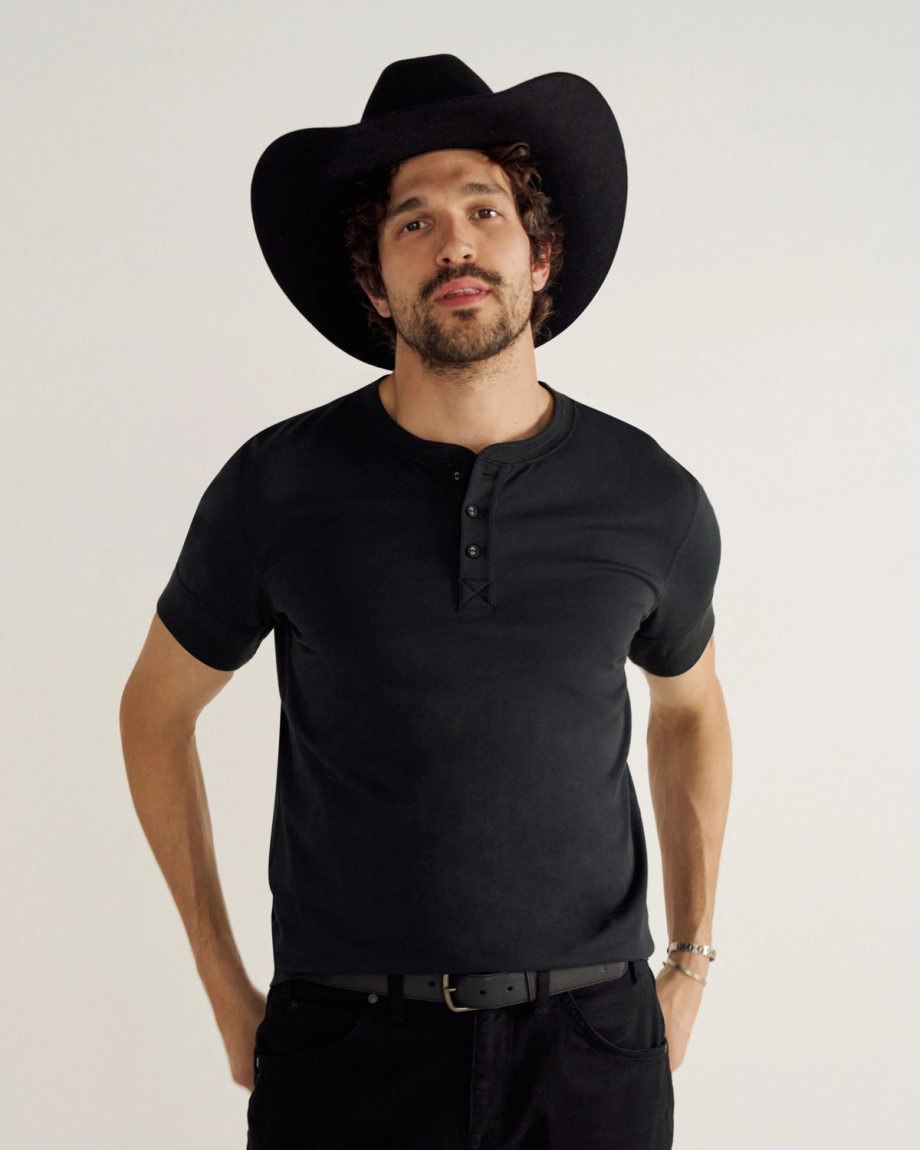 Man wearing a black henley in a studio