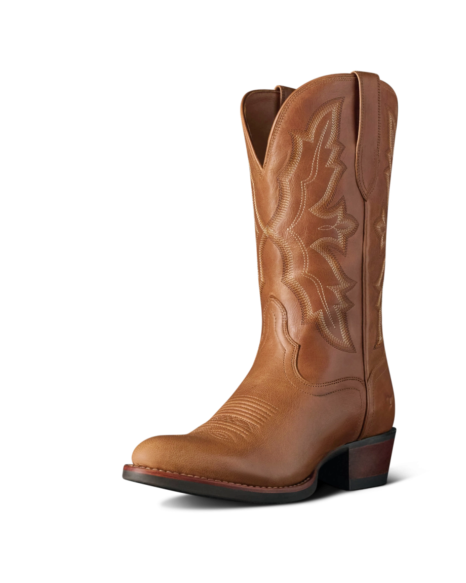 The Britt in Latte Goat. A single brown leather cowboy boot from The Britt Goat, featuring decorative stitching, a rounded toe, and a stacked heel, photographed on a plain white background.