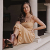 Woman wearing yellow sundress and brown booties