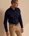 Man wearing navy cotton button down shirt with pearl snaps