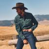 Man sitting on a fence wearing a button up and a cowboy hat