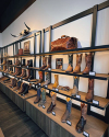 Interior of a boot store with shelves of various styles of cowboy boots, highlighting different patterns and colors, in a well-lit wooden display.