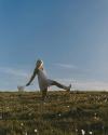 Woman in boots holding wildflowers in a field