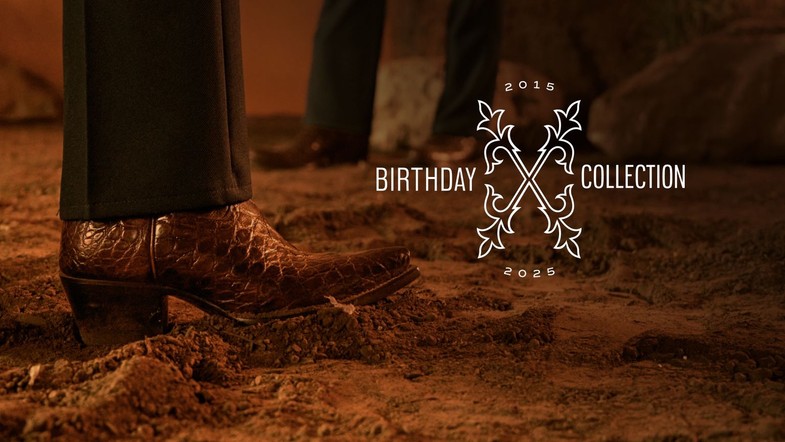 A close-up of a person wearing brown textured cowboy boots on dirt, with text reading "Birthday Collection 2015–2025" and a decorative design.