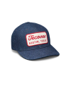 A blue denim baseball cap with a red and white patch on the front that reads "Tecovas Austin, Texas.