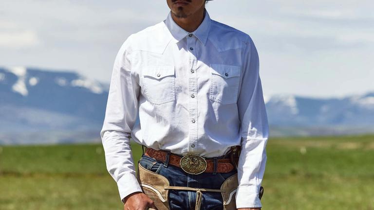 Image of cowboy holding a lasso in front of mountains | Tecovas