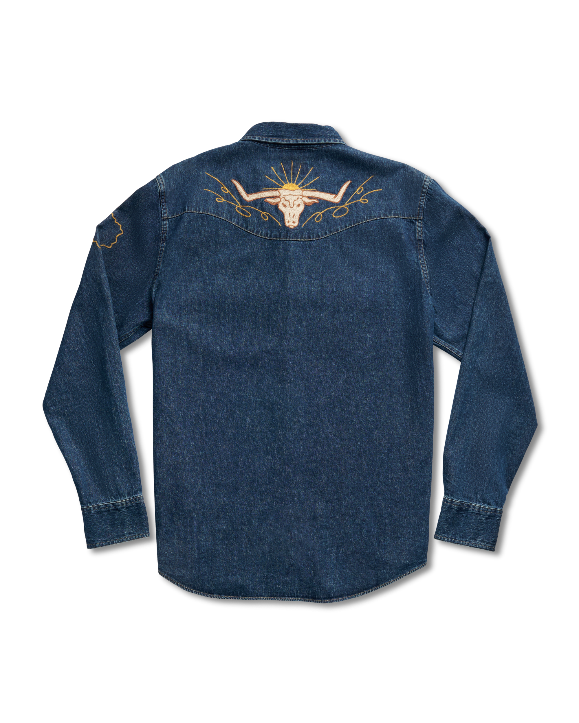 Back view of a dark denim shirt featuring a golden embroidered bull skull with sun rays on the upper back and a small design on the left sleeve.