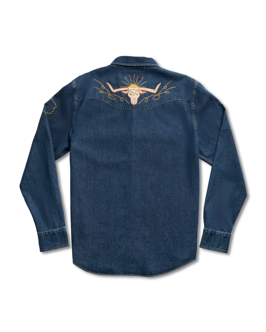 Back view of a dark denim shirt featuring a golden embroidered bull skull with sun rays on the upper back and a small design on the left sleeve.