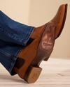 Lifestyle image of a man wearing the Chance chelsea boots in brandy brown