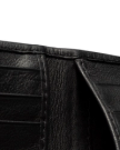 Close-up view of the inside of a black leather wallet against a black background.