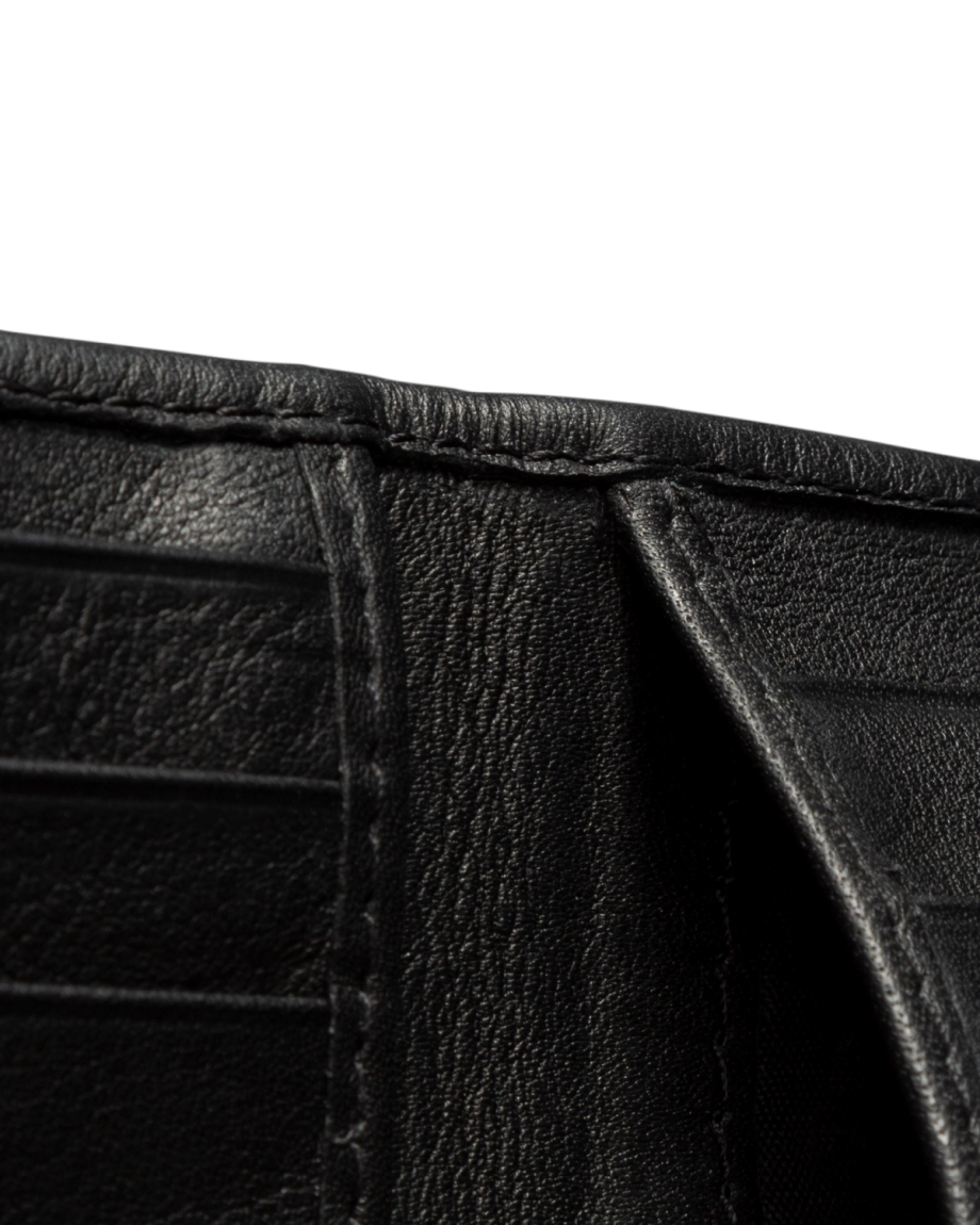 Close-up view of the inside of a black leather wallet against a black background.