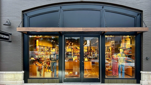 Storefront of Tecovas, featuring large glass doors and windows displaying boots and western wear. The store sign and street number 204 are visible above the entrance.