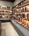Wall lined with cowboy boots in different colors and toe shapes