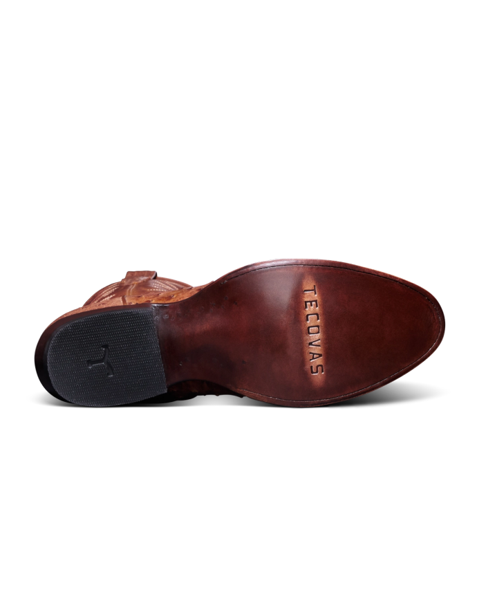 Bottom view of a brown leather boot with "Tecovas" imprinted on the sole. The heel is black with textured grip.