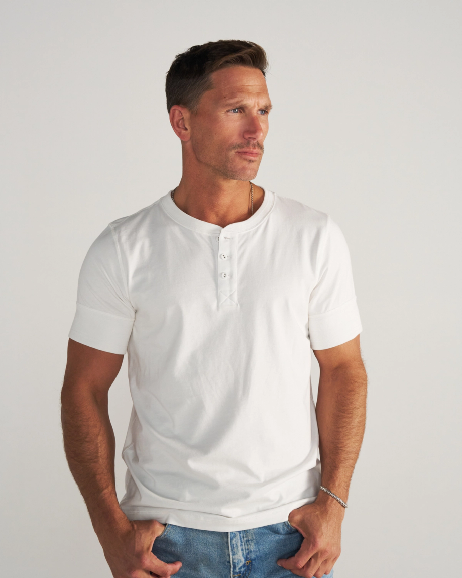 Man wearing a white henley in a photo studio
