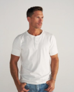 Man wearing a white henley in a photo studio