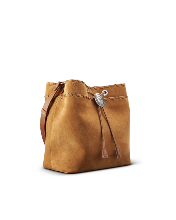 Brown suede bucket bag with leather straps and a decorative metallic clasp on a black background.