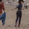 Woman in denim and cowgirl boots running through ranch