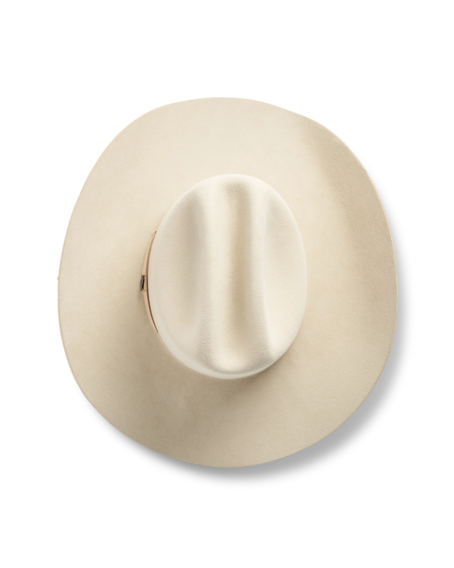 Top view of a wide-brimmed, cream-colored cowboy hat against a black background.