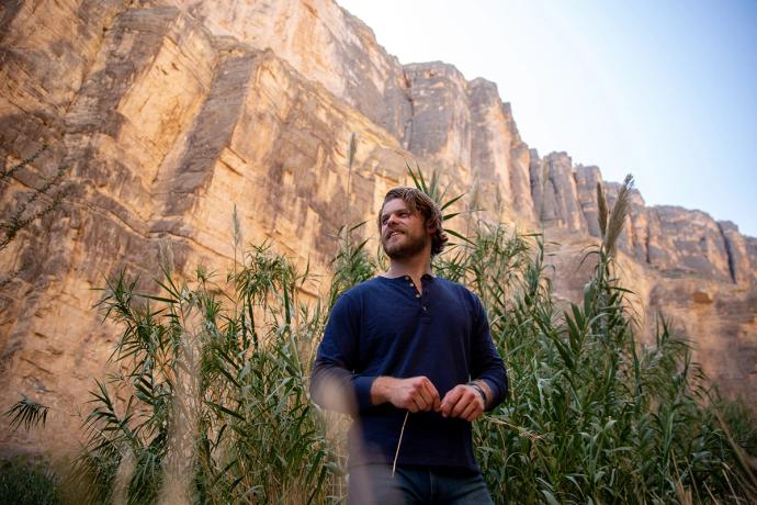 Man standing by a rock cliff, west texas landscape