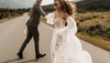 Couple in wedding attire dancing in a road