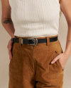 Closeup of woman wearing suede shorts and a black belt in a photo studio