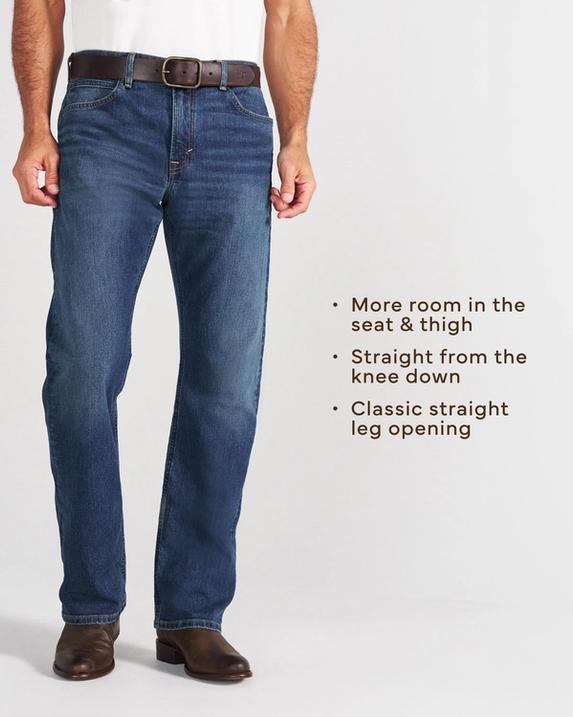 A person wearing a white t-shirt, blue jeans, and brown boots stands against a plain background.