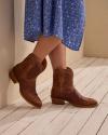 woman wearing the paige scotch brown goat cowgirl booties 