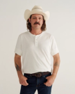 Man wearing a white henley in a photo studio