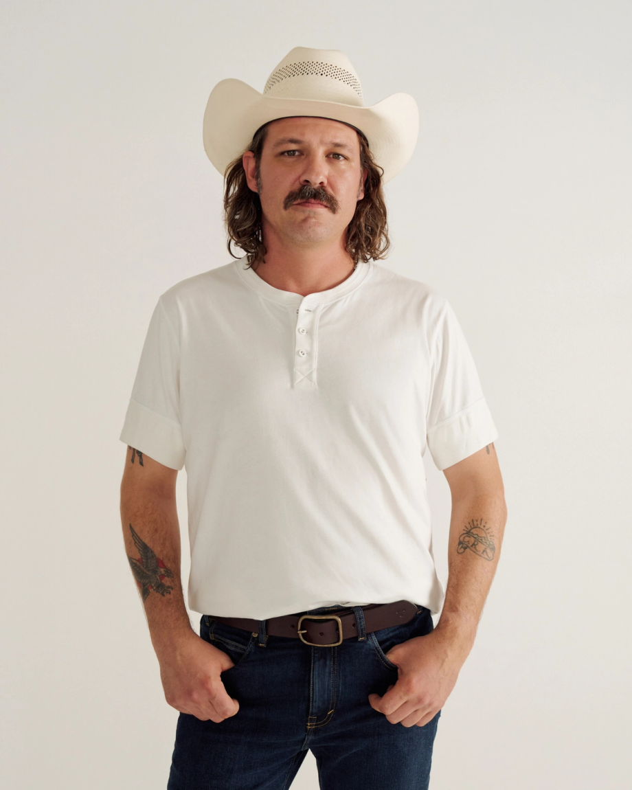 Man wearing a white henley in a photo studio