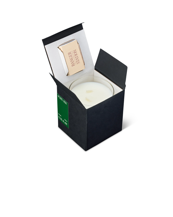 A black candle box is open, revealing a white candle and a small matchbox inside.