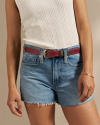 Closeup of woman wearing the three piece belt in red berry and jean shorts with a white tank top in a photo studio