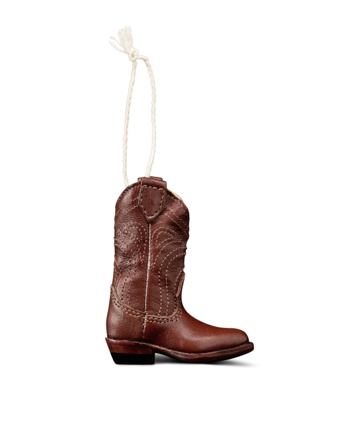 A small brown cowboy boot ornament with white stitching details, hanging by a white string against a plain white background.