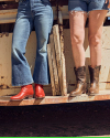 Closeup of two women standing on the back of a truck wearing The Beth in Crimson and Cafe