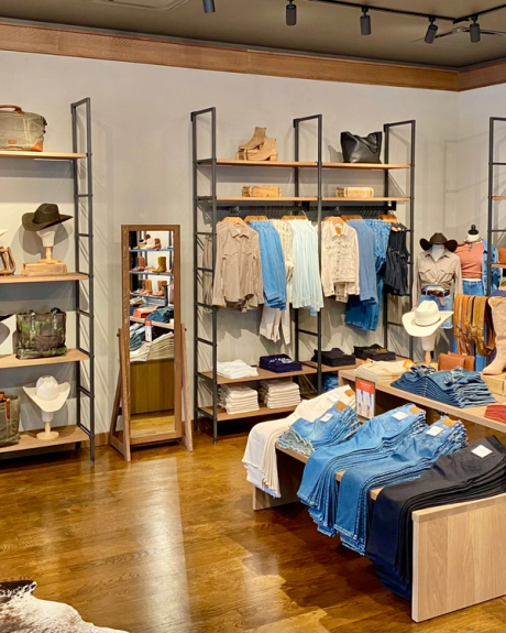 Interior of a boot store with shelves of various styles of western clothing